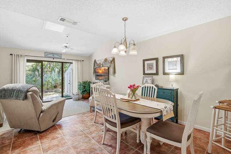 Bright open-concept beach stay featuring a cozy dining area and living space with sliding doors to a