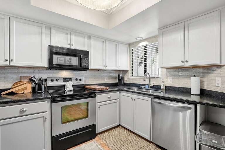 Clean and stylish beach stay kitchen featuring stainless steel appliances, ample counter space, and