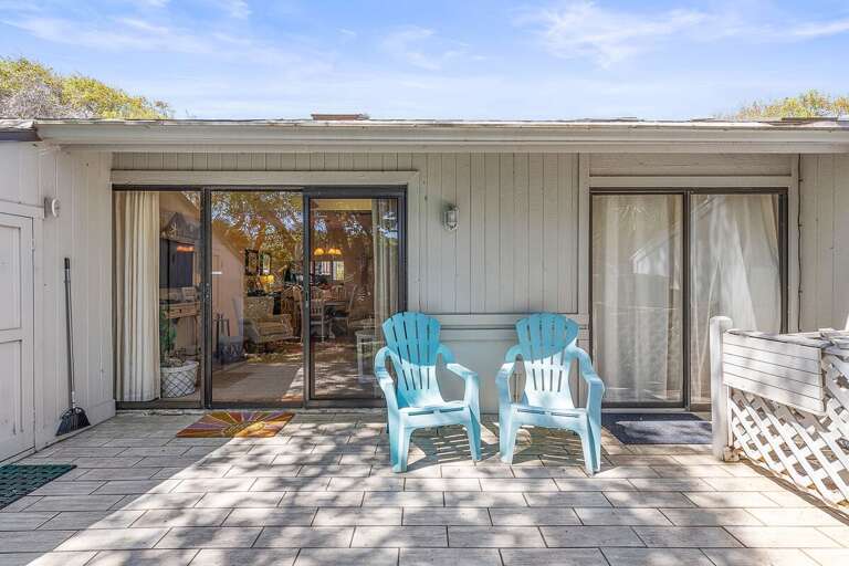 Enjoy your beach stay on this inviting patio with cozy seating and sliding glass door access to the living space. A perfect spot to relax, sip coffee, and unwind after a day at the beach.