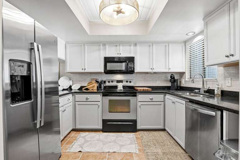 Fully equipped beach stay kitchen with stainless steel appliances, sleek countertops, and ample