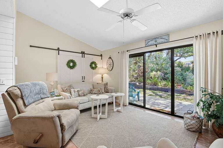 Inviting beach stay living room with plush seating, coastal accents, and large sliding doors leading