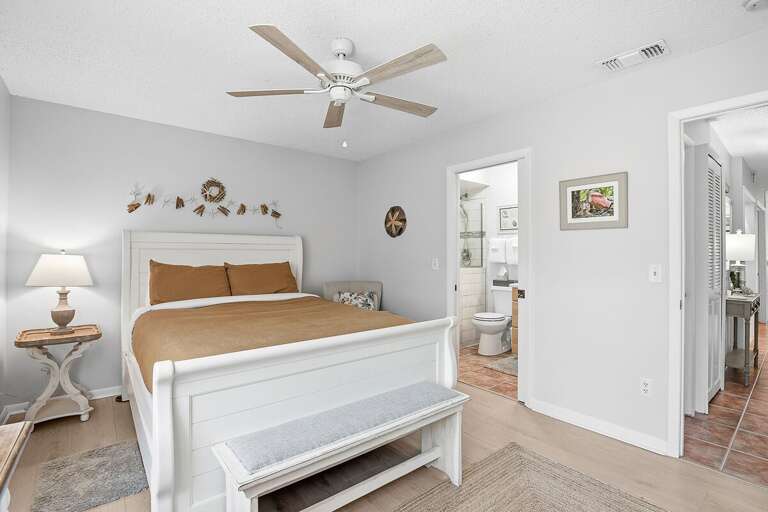 Relax in this inviting beach stay bedroom featuring a comfortable bed, soft coastal decor, and direct access to the bathroom. A bright, peaceful retreat perfect for unwinding after a day at the beach.