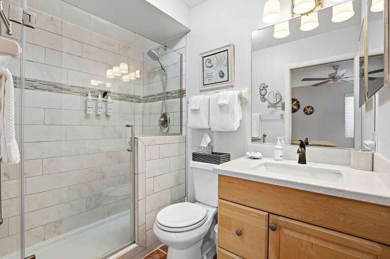 Stylish beach stay bathroom featuring a walk-in glass shower, modern fixtures, and fresh coastal touches. A clean, bright space perfect for refreshing after a relaxing day at the beach.