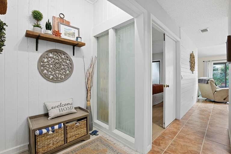 Stylish beach stay hallway featuring coastal decor, woven baskets, and a cozy bench nook. Bright and