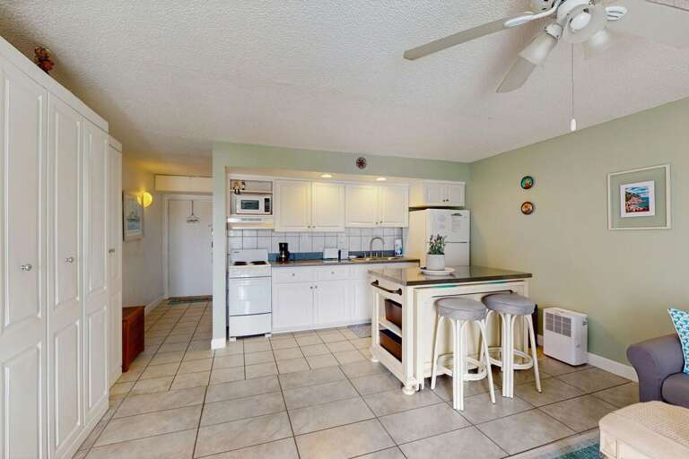 Bright, Spacious Kitchen In Vacation Rental With Tiled Floor And Ceiling Fan