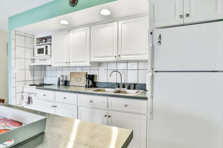 Bright, Breezy Kitchen In Vacation Rental With White Cabinets And Stainless Steel Appliances