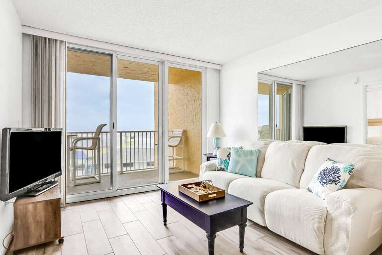 Light-filled Living Room Leading To Breezy Balcony In A Bright Beachside Vacation Rental