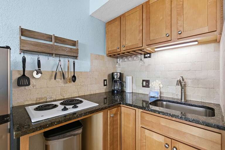 This beach stay studio features a convenient kitchenette with cooktop, sink, coffee maker, and