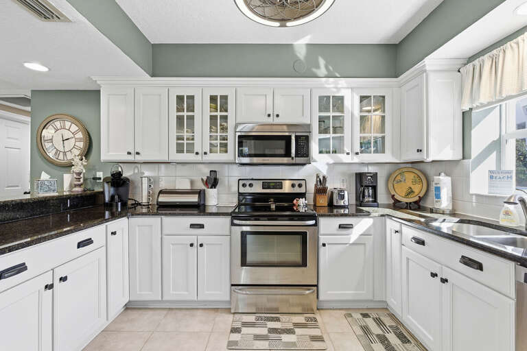 Fully equipped, sunlit kitchen with modern appliances, ample counter space, and coastal charm. Perfect for preparing meals during your beach stay, just steps from relaxation and ocean-inspired living.