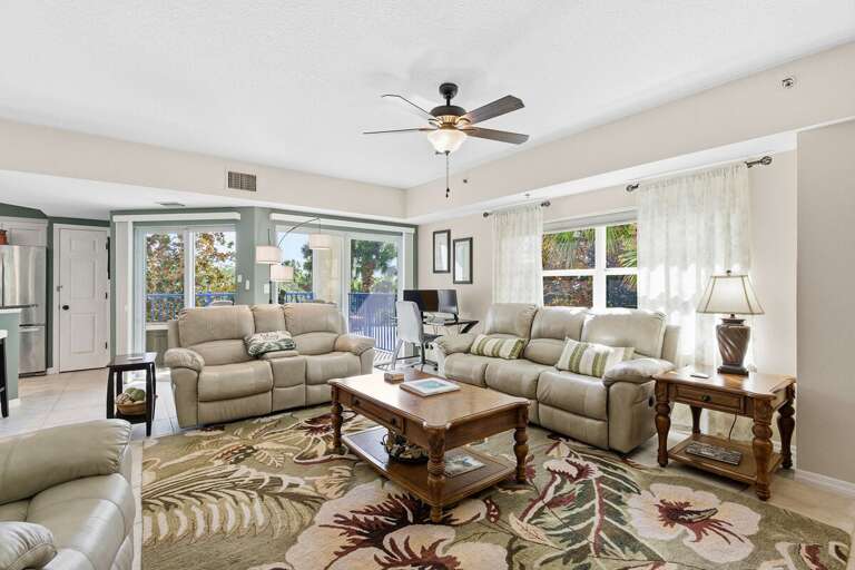Inviting living area with plush seating, natural light, and balcony access—ideal for your beach