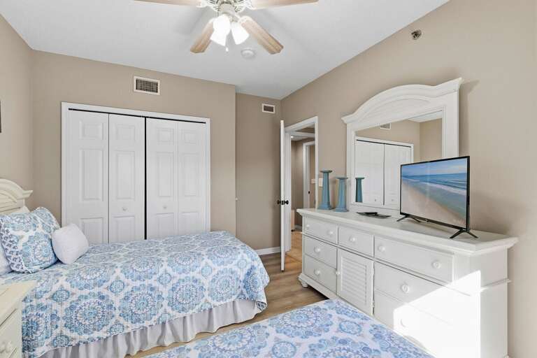 Relax in this bright guest bedroom with twin beds, coastal décor, and TV for added comfort. Ideal for your beach stay, offering a relaxing retreat for family or friends after a fun day by the ocean.