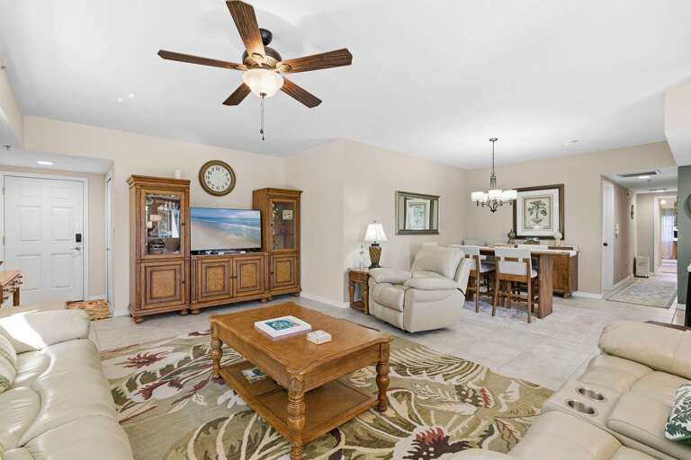 Spacious open-concept living and dining area with cozy seating, TV, and stylish furnishings. Perfect for gathering and unwinding during your beach stay after a fun day by the ocean.