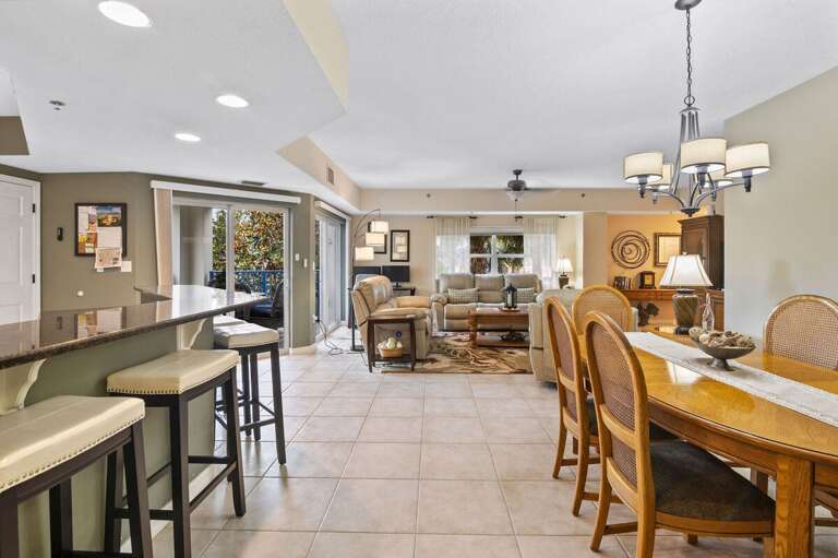 This spacious open floor plan connects the kitchen, dining, and living areas with easy balcony
