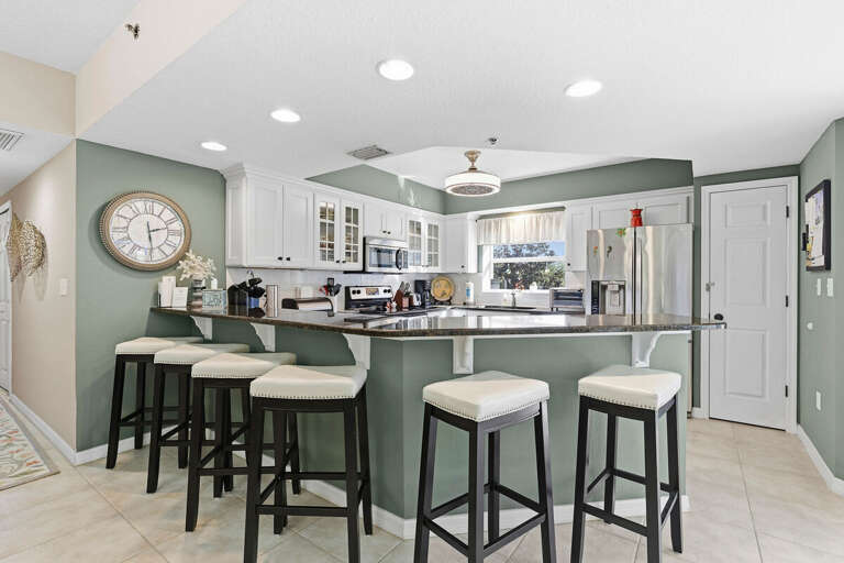 Stylish open kitchen with spacious breakfast bar seating, modern appliances, and coastal charm. Perfect for gathering and dining during your beach stay after a fun-filled day by the ocean.