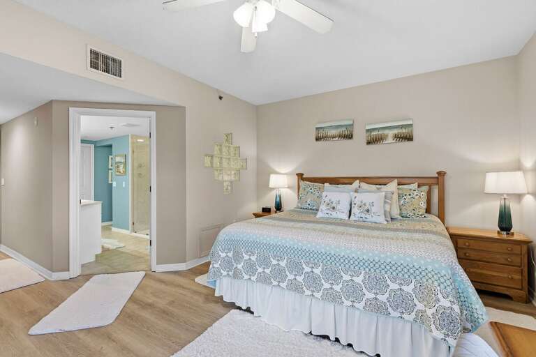Unwind in this spacious master suite featuring a plush king bed, soft coastal décor, and private