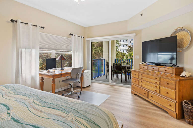 Wake up to natural light and step onto your private balcony from this spacious coastal bedroom.