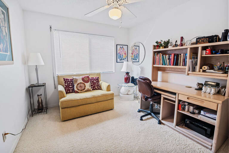 Bright, versatile space with desk, bookshelves, and comfy seating—ideal for remote work or quiet