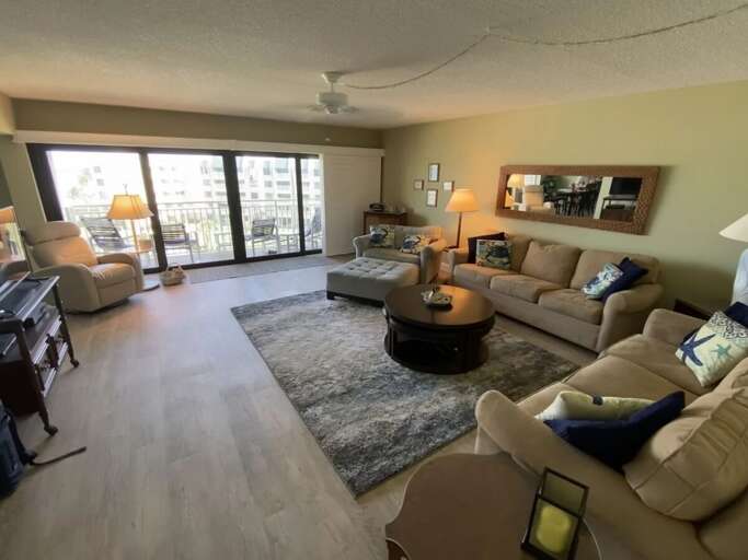 Bright and spacious living room in this relaxing beach stay featuring comfortable seating, coastal