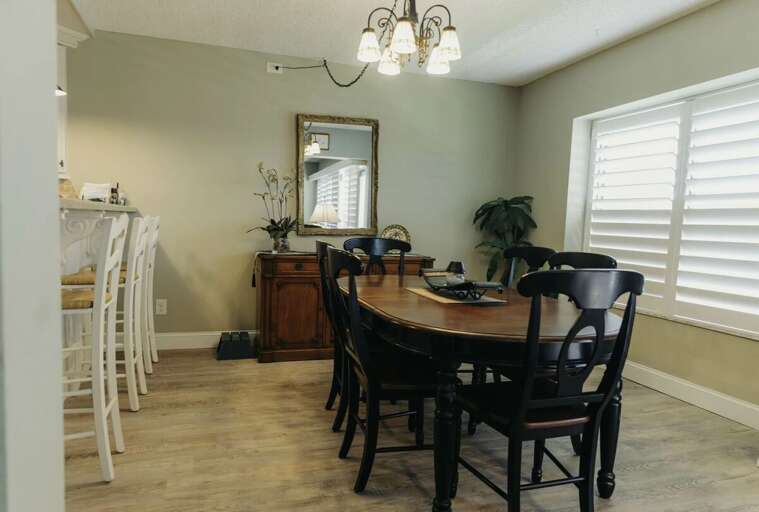 Enjoy meals in this inviting beach stay dining room featuring a spacious table, elegant lighting,