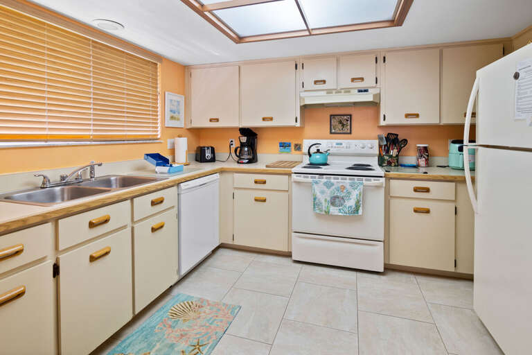 This bright, fully equipped kitchen is perfect for your beach stay, featuring full-size appliances,