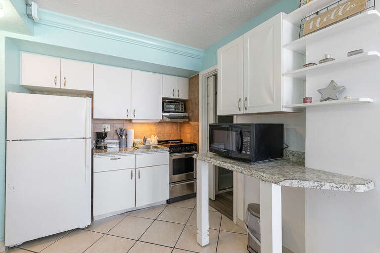 Enjoy a fully equipped coastal kitchen during your beach stay, featuring modern appliances, ample