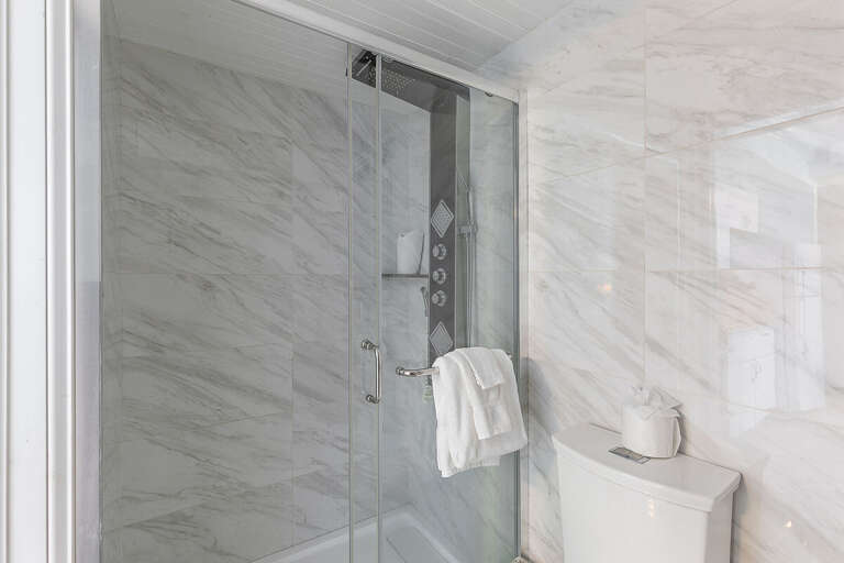 Refresh after a day in the sun with this sleek walk-in shower, featuring stylish tile and modern fixtures. A clean, spa-like bathroom adds comfort and convenience to your relaxing beach stay.