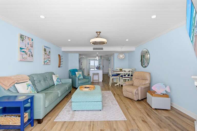 This inviting beach stay features an open-concept living and dining area with comfortable seating and coastal décor. Perfect for relaxing, gathering, and enjoying a breezy seaside retreat.