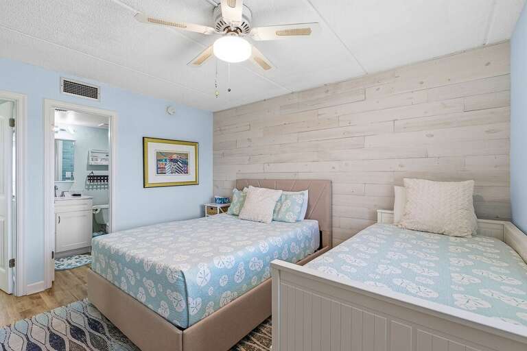 Perfect for families, this beach stay bedroom features multiple beds, coastal décor, and a bright, relaxing atmosphere. A comfortable space to unwind after a fun-filled day by the beach.