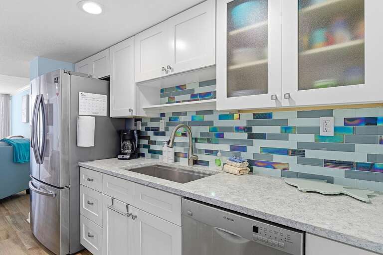 This beach stay features a bright coastal kitchen with modern appliances, sleek countertops, and a