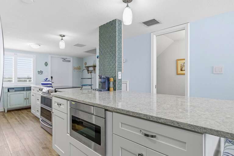 This beach stay offers a spacious open kitchen with a large island, modern appliances, and coastal design. Perfect for gathering, cooking, and enjoying easy, breezy meals after a day at the beach.