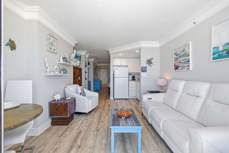 Inviting beach stay living space with cozy seating, coastal décor, and an open layout leading to