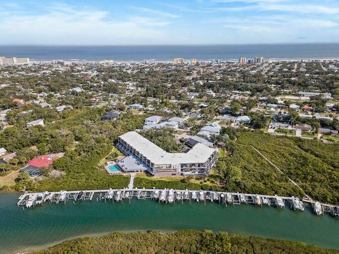 Discover the perfect beach stay with this aerial view of a waterfront condo, private marina, and