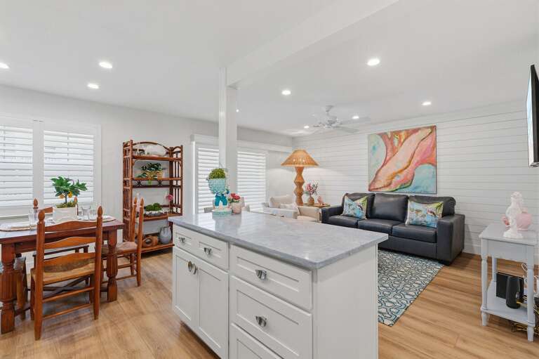 Enjoy an inviting beach stay with this open-concept living, dining, and kitchen area featuring coastal décor, bright natural light, and plenty of space to relax after a day at the beach.