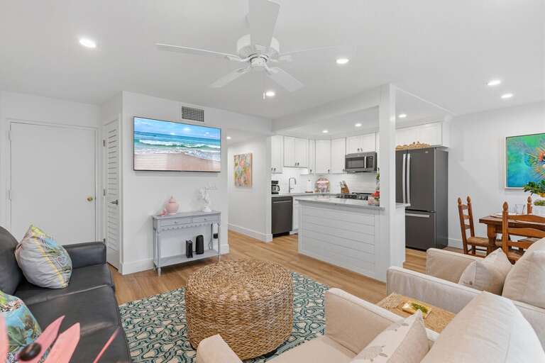 Enjoy a relaxing beach stay in this bright open-concept space featuring cozy seating, a modern kitchen, and coastal-inspired décor—perfect for gathering after a day at the beach or pool.