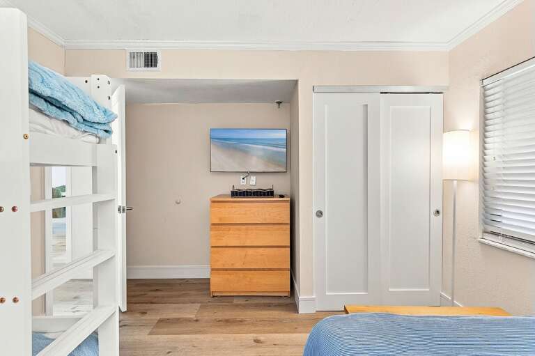 Designed for families, this coastal bedroom offers bunk beds, ample storage, and a TV for added comfort. A bright, functional space where everyone can relax and recharge after a fun-filled beach stay.