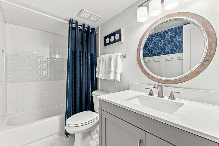 Freshen up in this stylish coastal bathroom featuring a modern vanity with quartz countertop and a