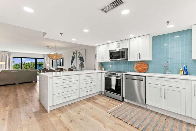 Prepare meals in this bright, modern coastal kitchen featuring quartz countertops, stainless steel