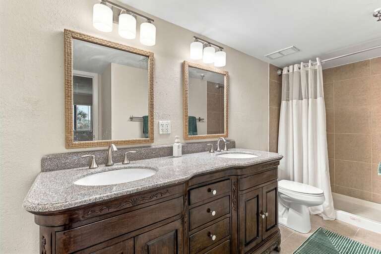 Refresh in this spacious bathroom featuring a double vanity, granite countertops, and a walk-in