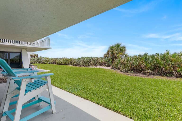 Relax on your private ground-floor patio with Adirondack chairs, lush tropical landscaping, and