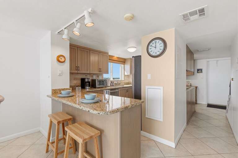 Enjoy a functional kitchen with granite countertops, modern appliances, ample cabinetry, and a