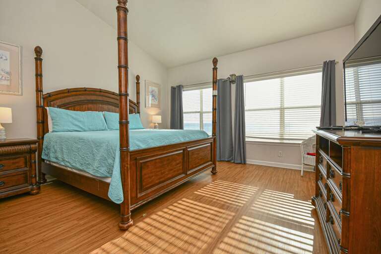 Sunlit master bedroom with serene waterfront views