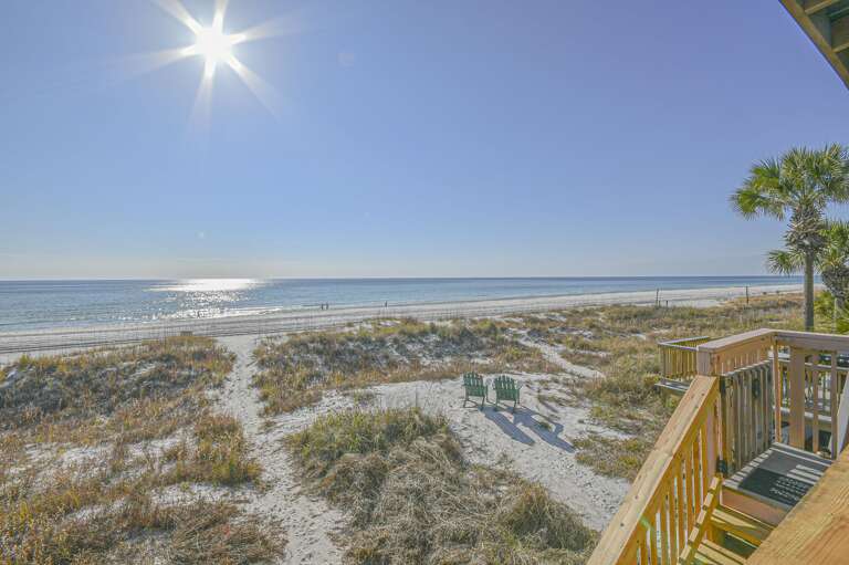Sunlit balcony with stunning ocean views and sandy dunes