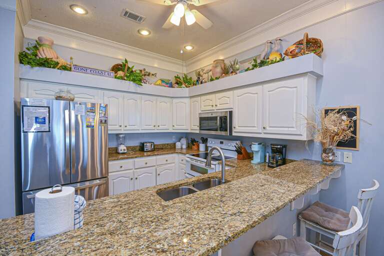 Bright kitchen with granite countertops and stainless steel appliances