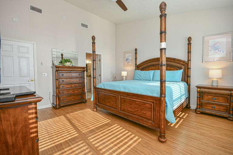 Spacious master bedroom with elegant four-poster bed and natural light