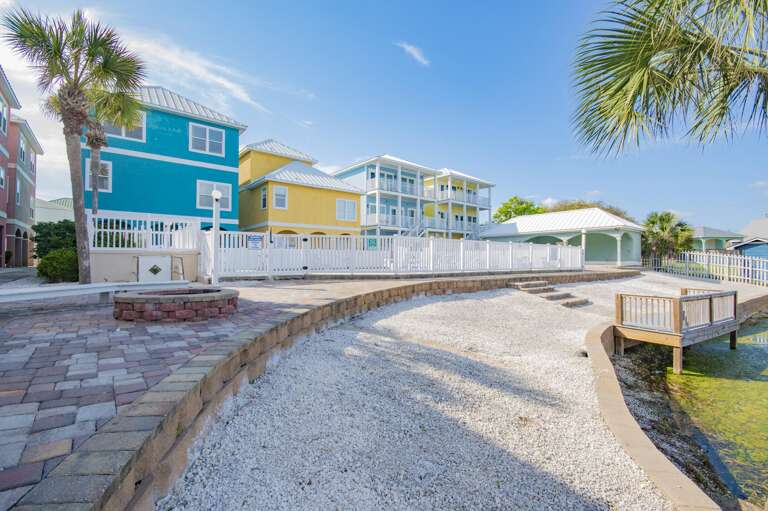 Waterfront walkway with vibrant coastal homes and palm trees