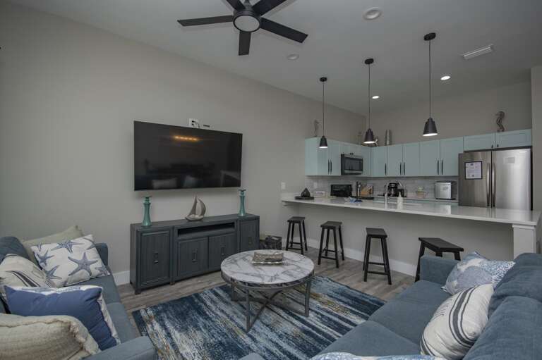Cozy living room with modern kitchen and breakfast bar seating