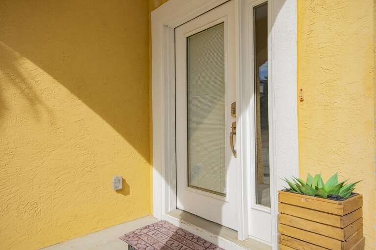 Sunny entryway with vibrant yellow walls and greenery