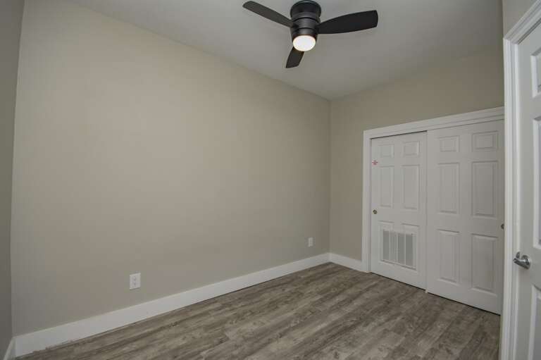 Cozy bedroom retreat with modern ceiling fan and wood floors