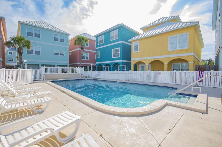Vibrant poolside retreat with colorful townhomes and sunny loungers