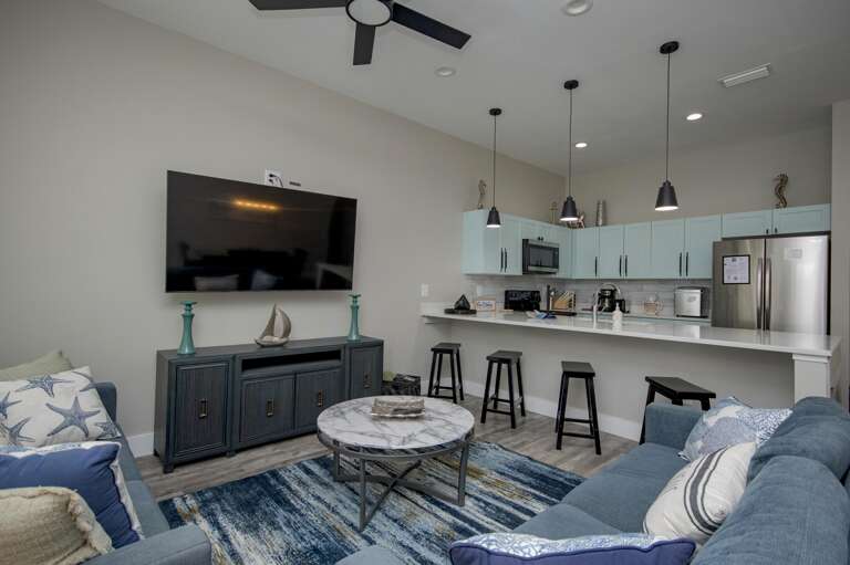 Cozy living room with modern kitchen and breakfast bar seating
